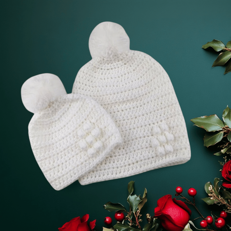 Matching ladies and baby white crocheted hats with detachable faux fur pompoms