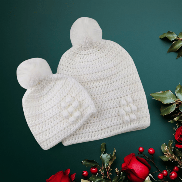 Matching ladies and baby white crocheted hats with detachable faux fur pompoms