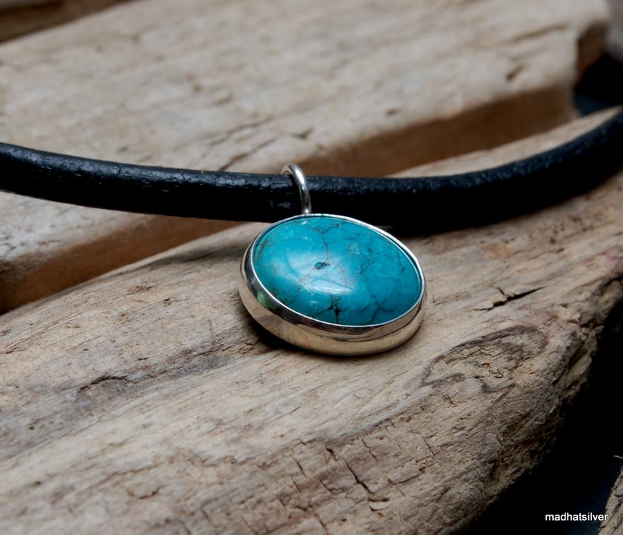 Turquoise and silver pendant on leather cord