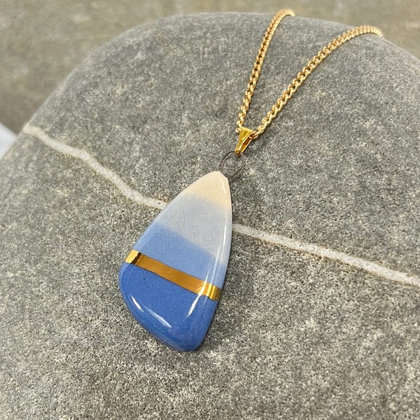 Pebble shaped pendant in blue tones with 24karat Gold detail