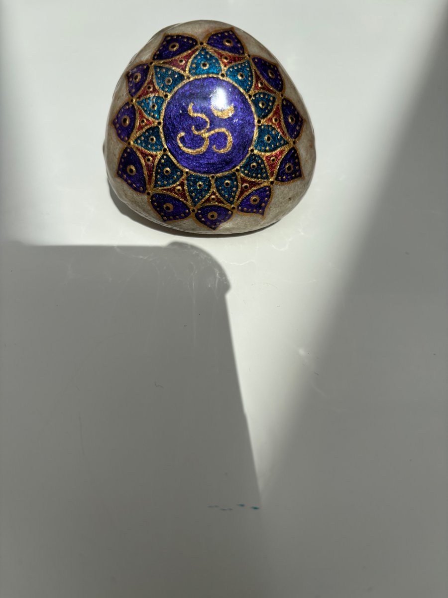 Hand painted om symbol on natural rock