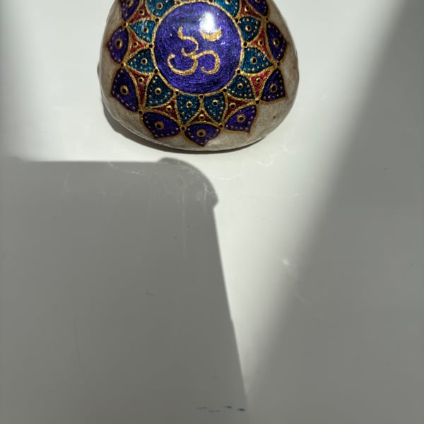 Hand painted om symbol on natural rock