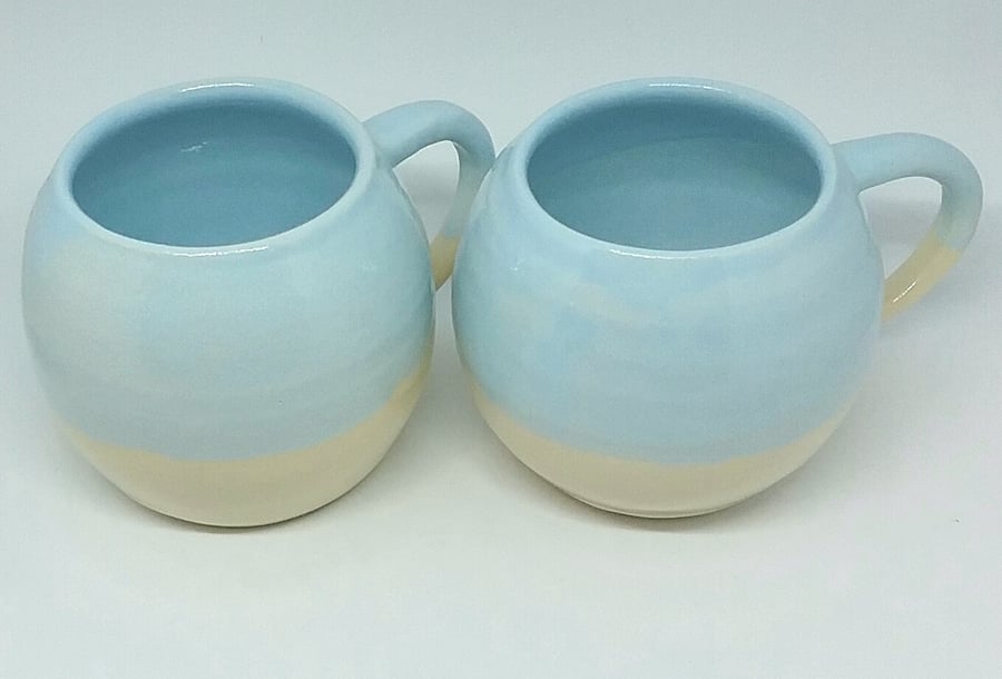 Handmade ceramic mug with pale blue and clear glaze on handthrown white clay 