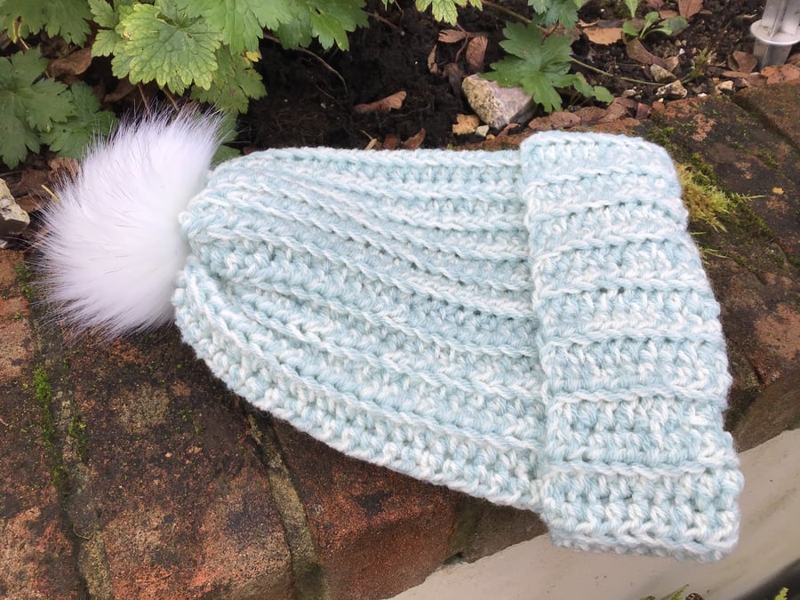 Winter hat in turquoise and cream blend acrylic yarn with faux fur Pom pom