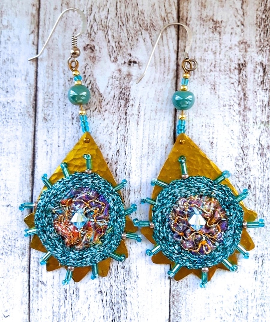 Textile embroidery and brass earrings.