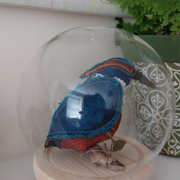 Kingfisher inspired soft sculpture in glass case.