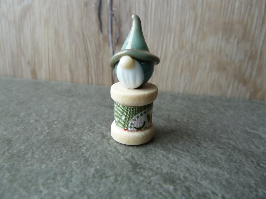 wooden spool with green gnome