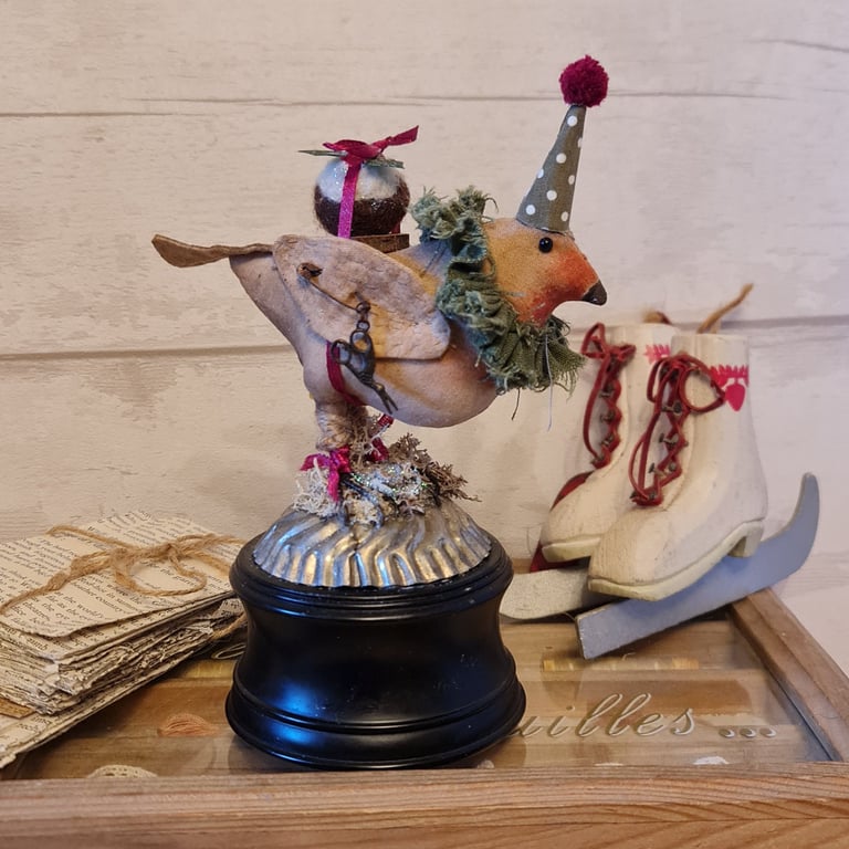 Heirloom Robin with pudding on a wind up musical textile art soft sculpture.