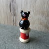 glass cat on wooden bobbin 