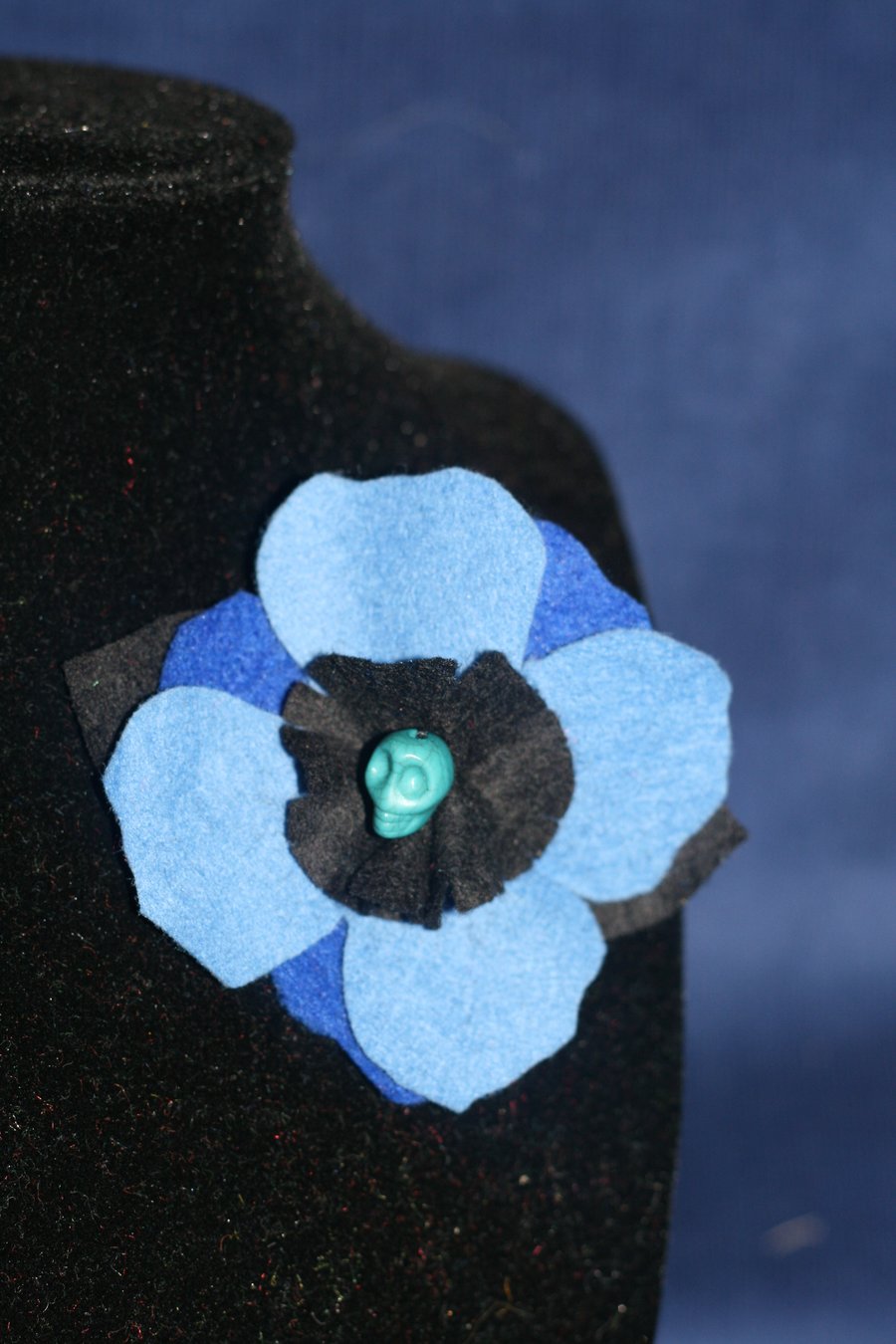Blue and black felt flower brooch with skull bead