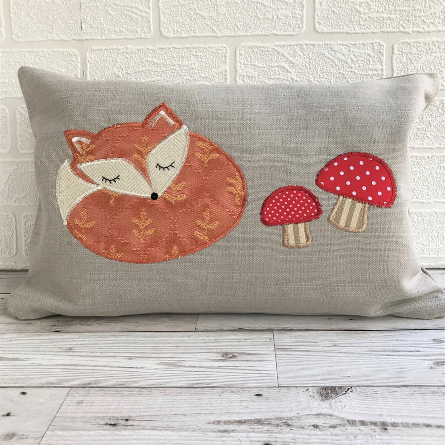  Sleepy fox cushion in pale taupe with terracotta fox and red toadstools