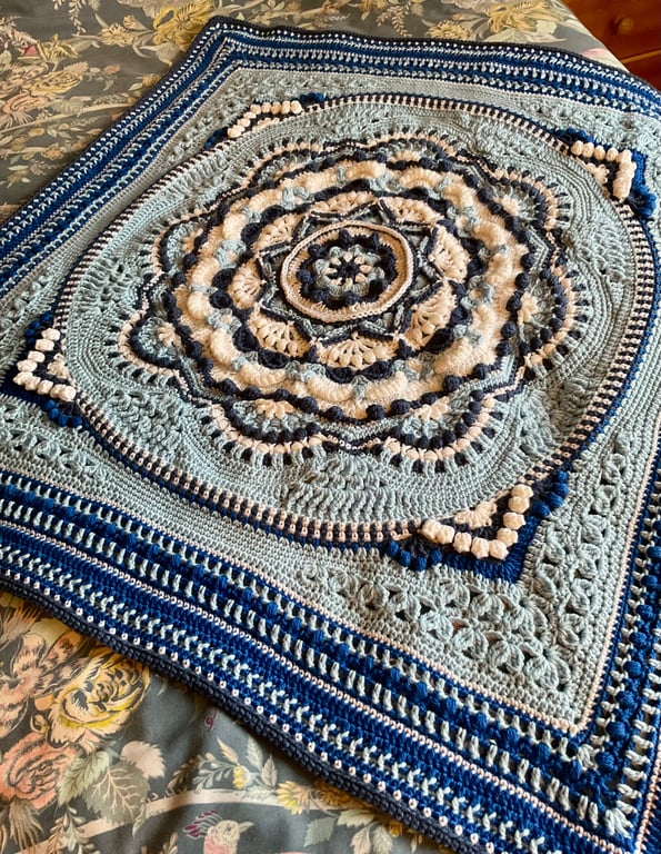 Small blue and white baby blanket or lap blanket.