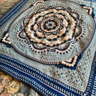 Small blue and white baby blanket or lap blanket.