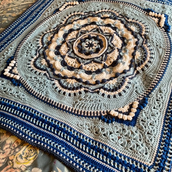 Small blue and white baby blanket or lap blanket.