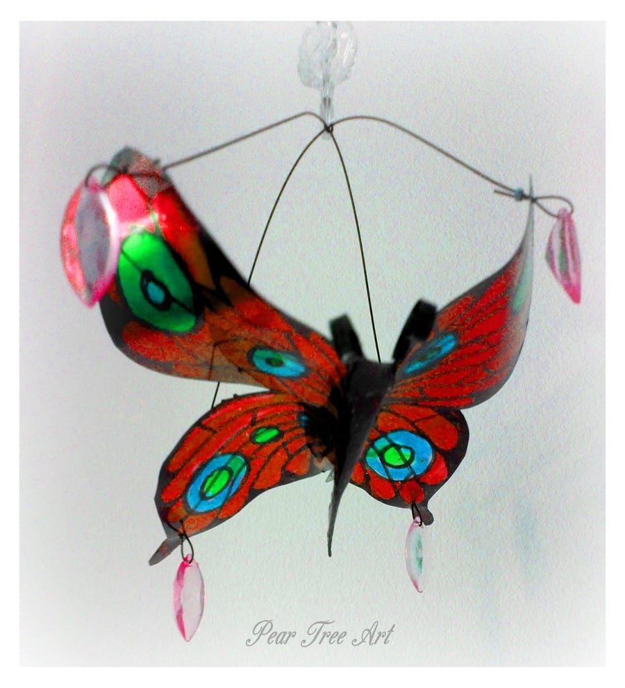 Red metal butterfly hanging decoration made from a coffee tin.