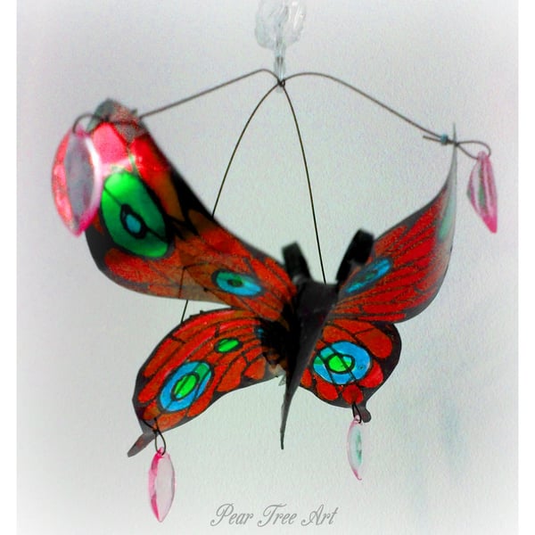 Red metal butterfly hanging decoration made from a coffee tin.