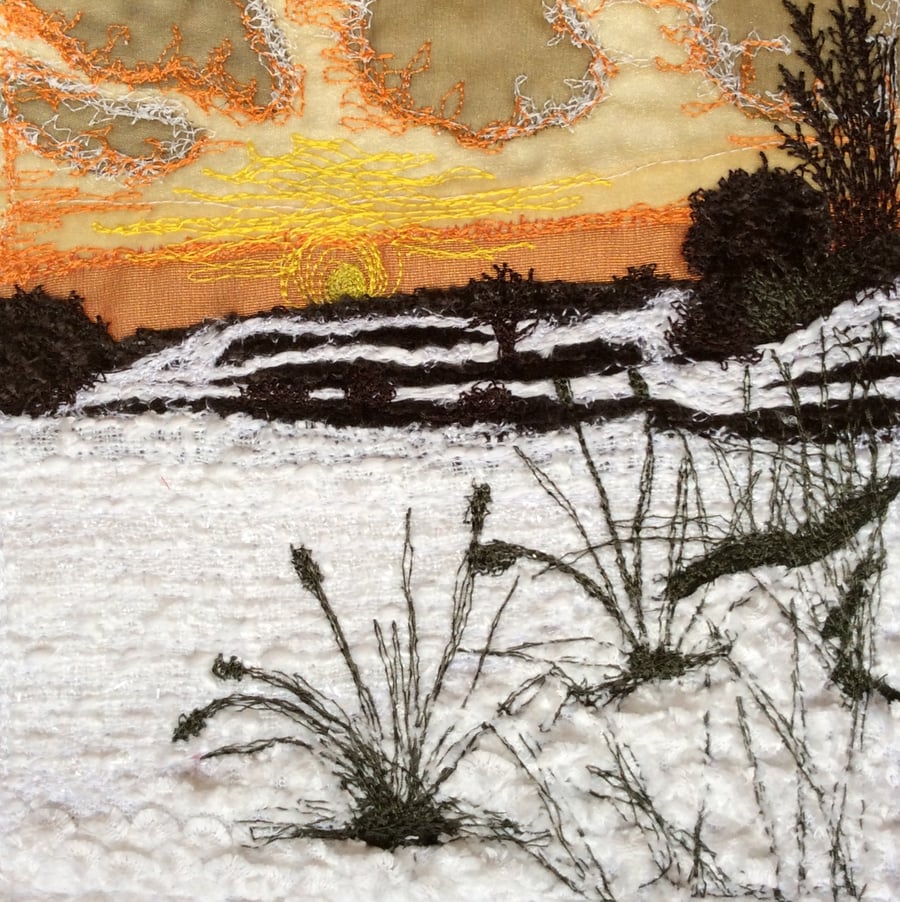 Embroidered sunset landscape.