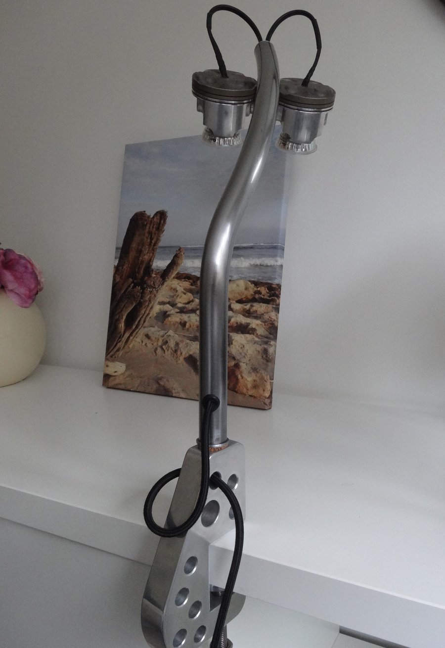 A one of a kind clamp on piston desk or table lamp