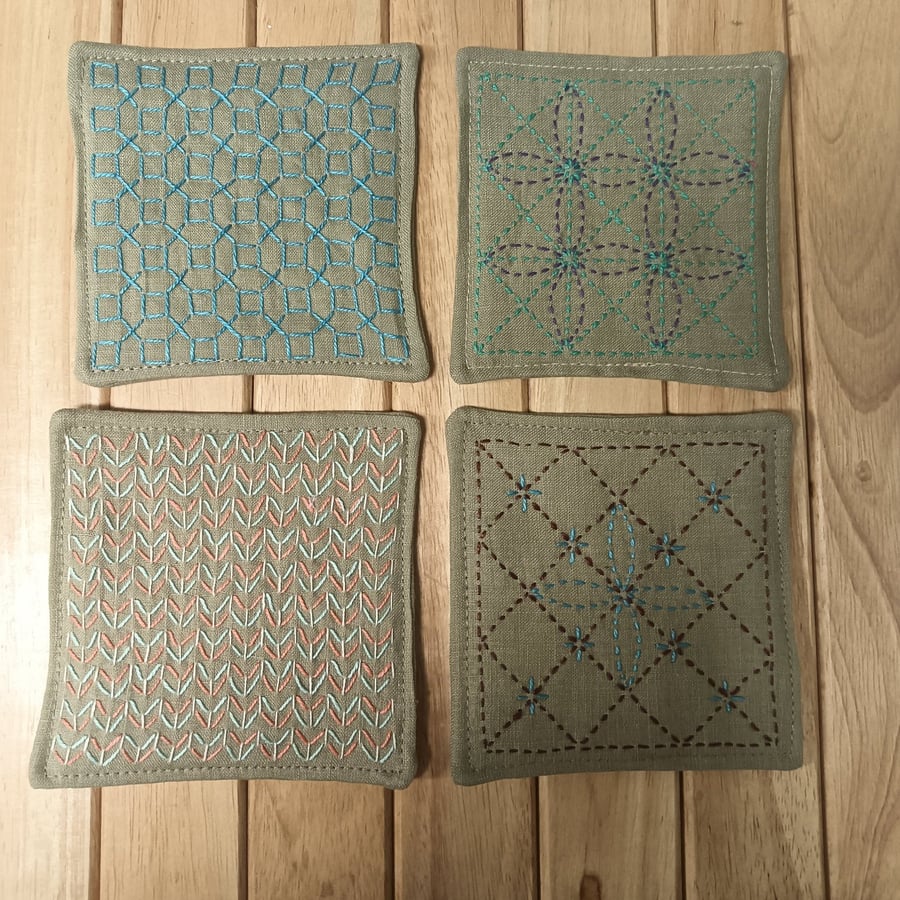 Set of four beige linen coasters with sashiko embroidery detail