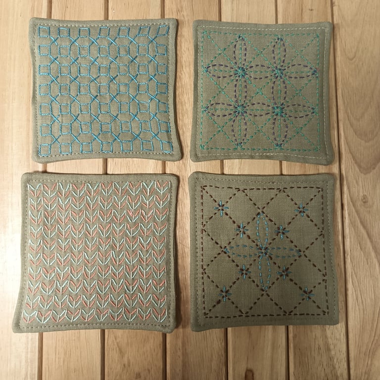 Set of four beige linen coasters with sashiko embroidery detail