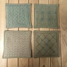 Set of four beige linen coasters with sashiko embroidery detail