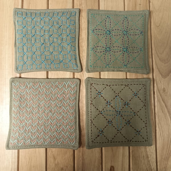 Set of four beige linen coasters with sashiko embroidery detail