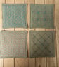 Set of four beige linen coasters with sashiko embroidery detail