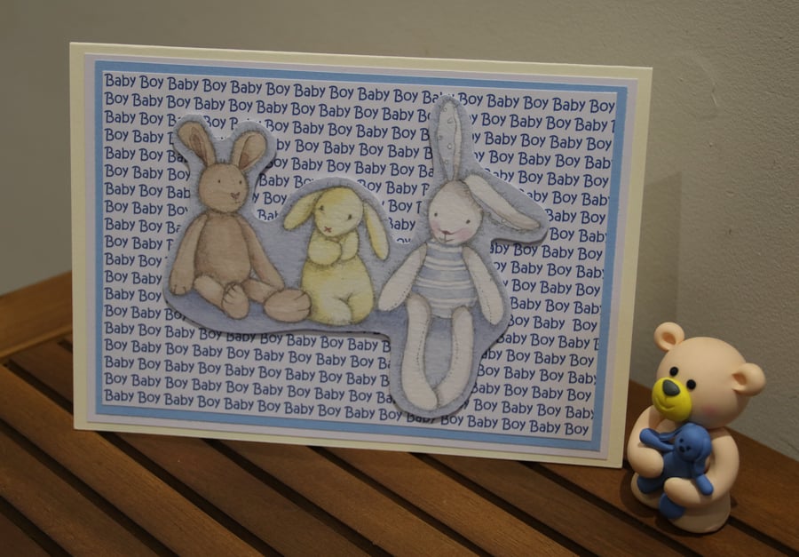 New baby Boy card, rabbit toys, printed text background