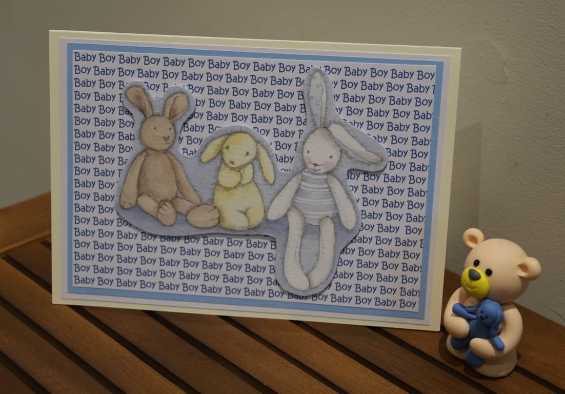 New baby Boy card, rabbit toys, printed text background