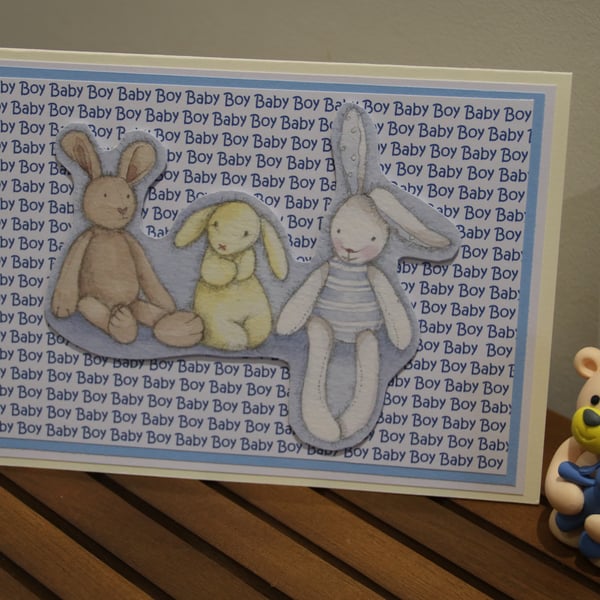 New baby Boy card, rabbit toys, printed text background
