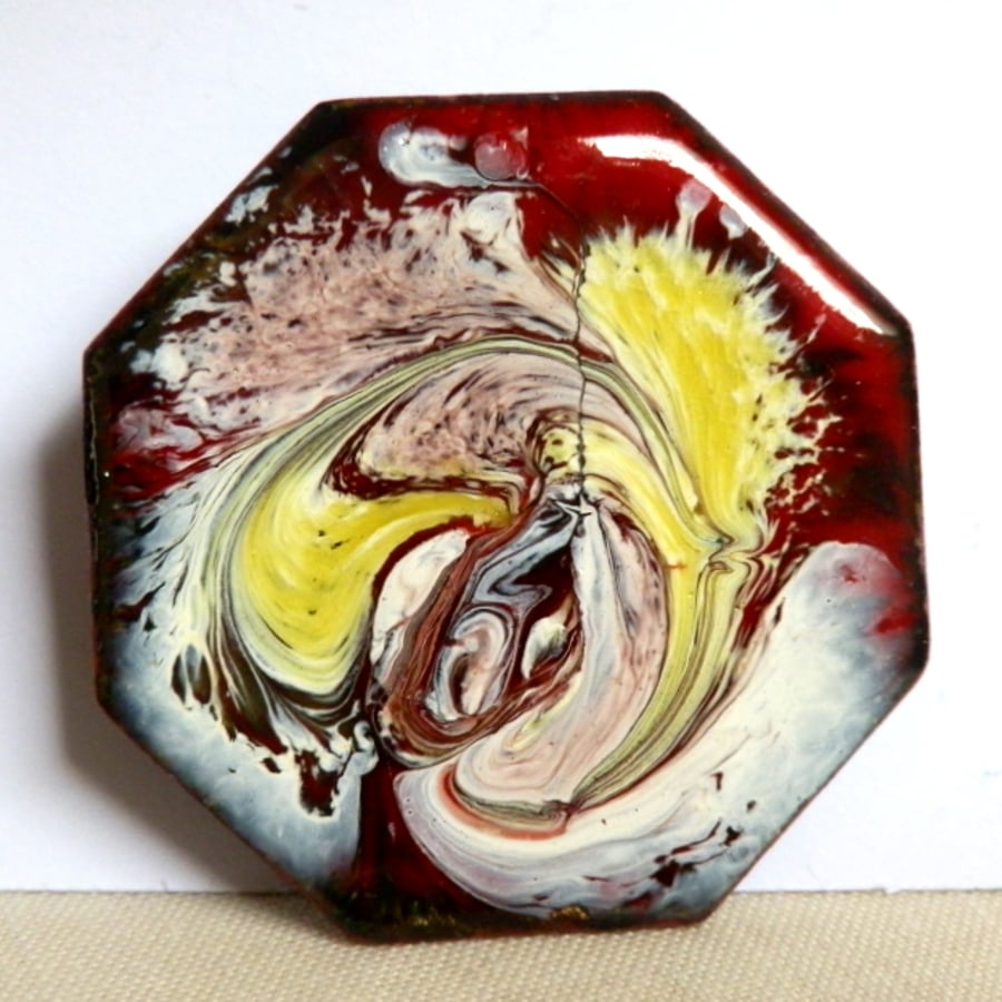 yellow and white scrolled over red - brooch