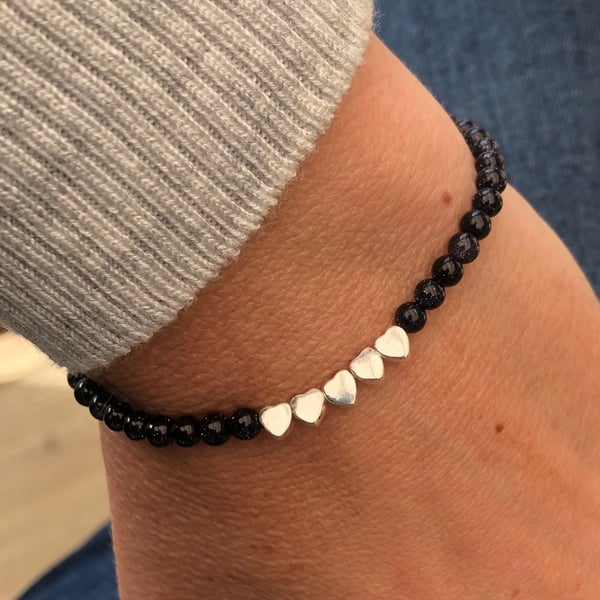 Blue goldstone beaded bracelet with five hearts.