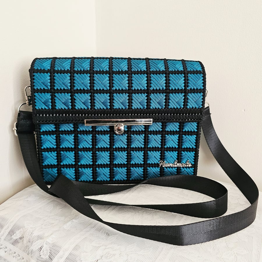 Geometric pattern crossbody bag with adjustable strap.