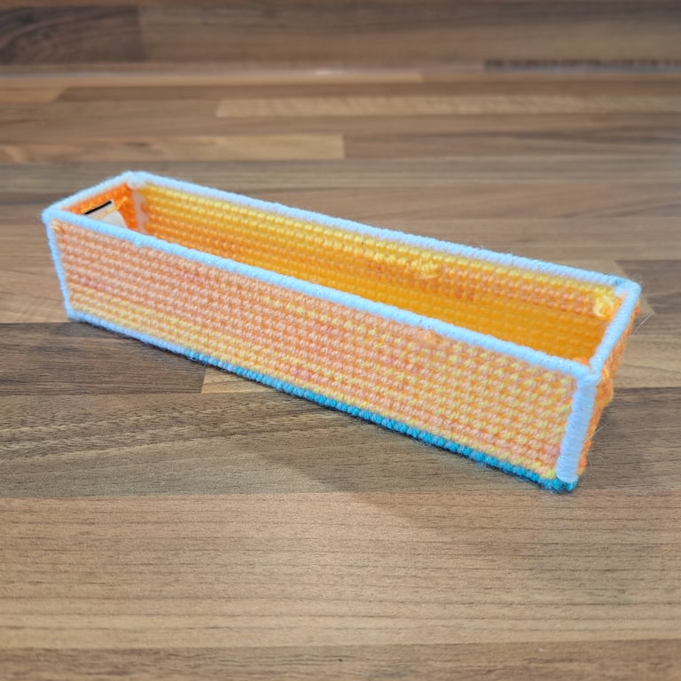 Pencil case - yellow, orange, and pink with blue and white edging, open-top