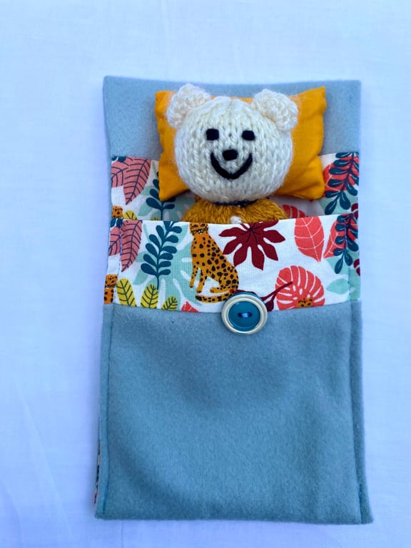 Hand knitted ted in a bed, companion bear