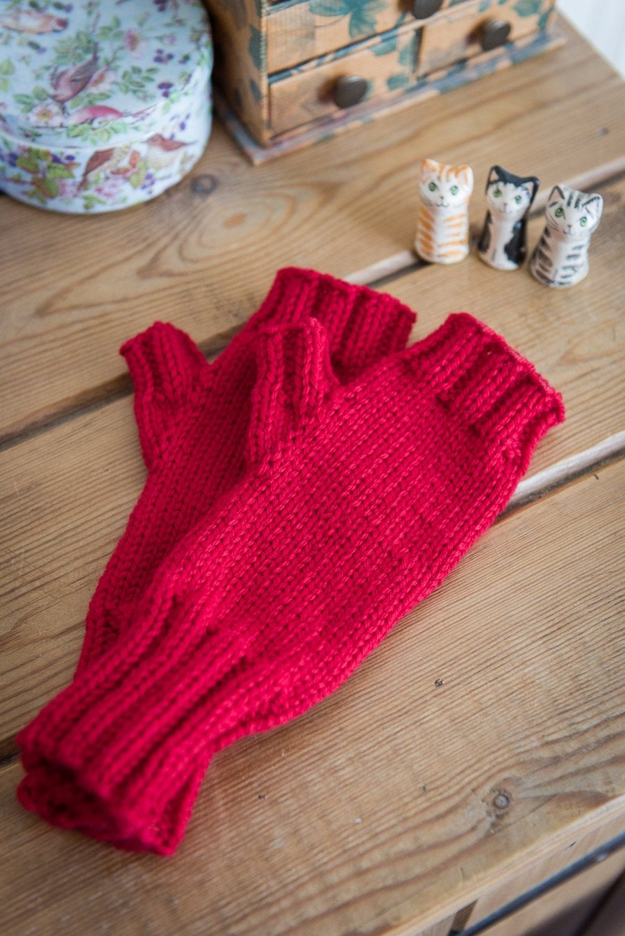 Fingerless mittens, hand knit in a bright red colour, using soft washable wool