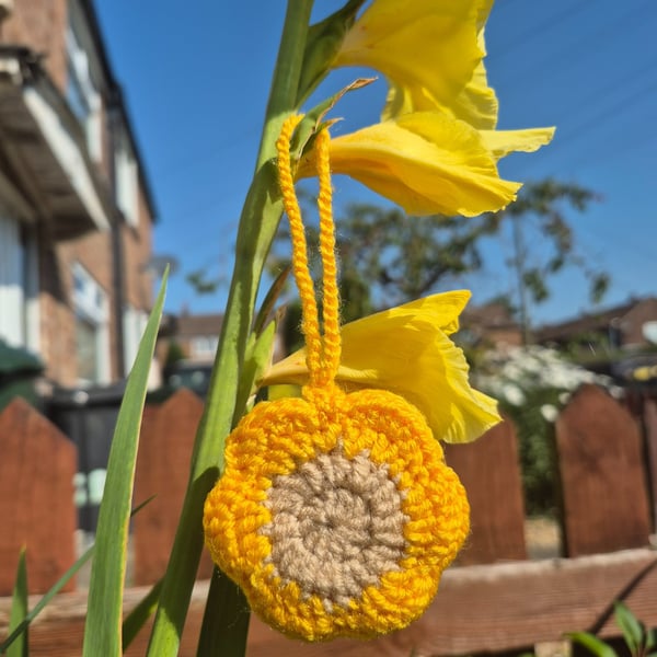 Flower shaped bag charm with small storage space.