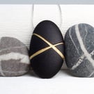 Black Pebble prndant with gilded lines which hangs on a sterling silver chain 