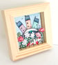 Little houses on a fabric hill, with flowers, in small wooden frame - Image 1