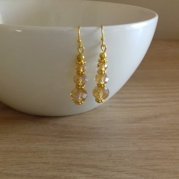 FACETED GOLD RONDELLE GLASS BEAD EARRINGS.