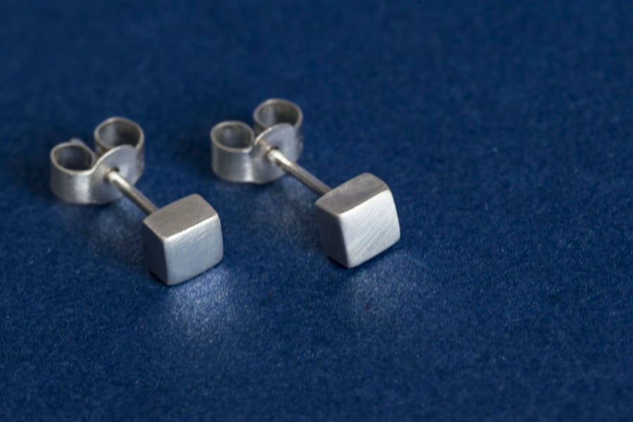 Silver cube stud earrings with a brush matte textured finish
