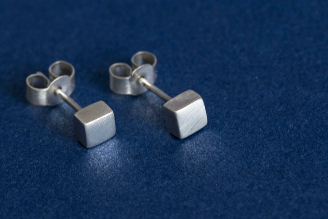 Silver cube stud earrings with a brush matte textured finish