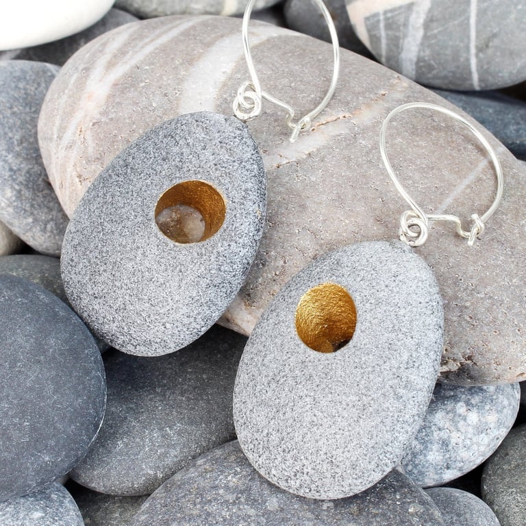 Pebble earring with gilded holes that go through the stones. Nature inspired