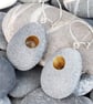 Pebble earring with gilded holes that go through the stones. Nature inspired
