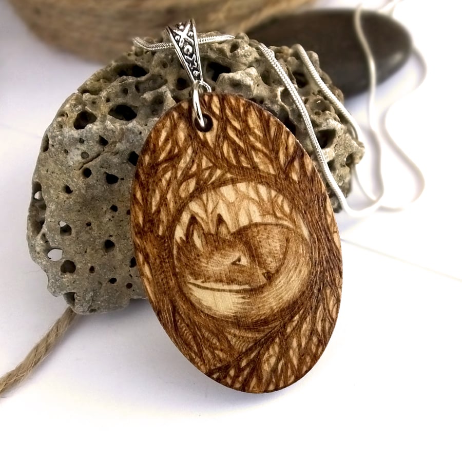 Sleepy fox cub in the woods, oval pyrography wooden pendant.
