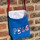 Blue peg bag with red shoulder strap. 