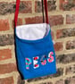 Blue peg bag with red shoulder strap. 