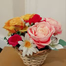 Artificial flowers set in wicker basket