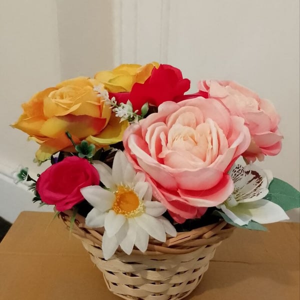 Artificial flowers set in wicker basket