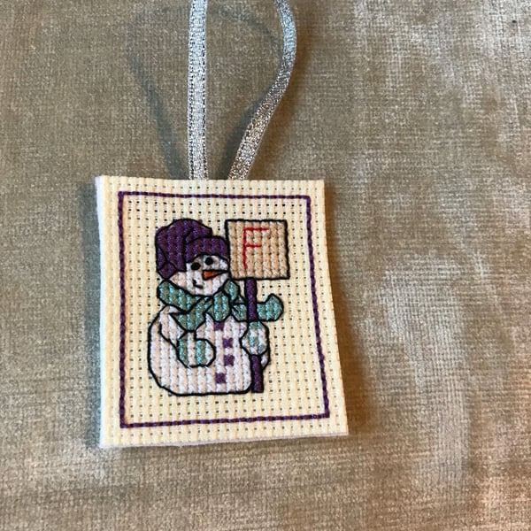 Cross stitched letter F snowman . Christmas tree decoration with an initial F . 